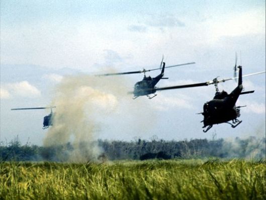 Huey lift platoon in Vietnam descending into landing zone to dispatch infantry troops.  